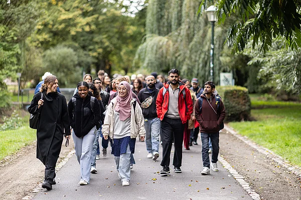 Menschen gehen durch einen Park.