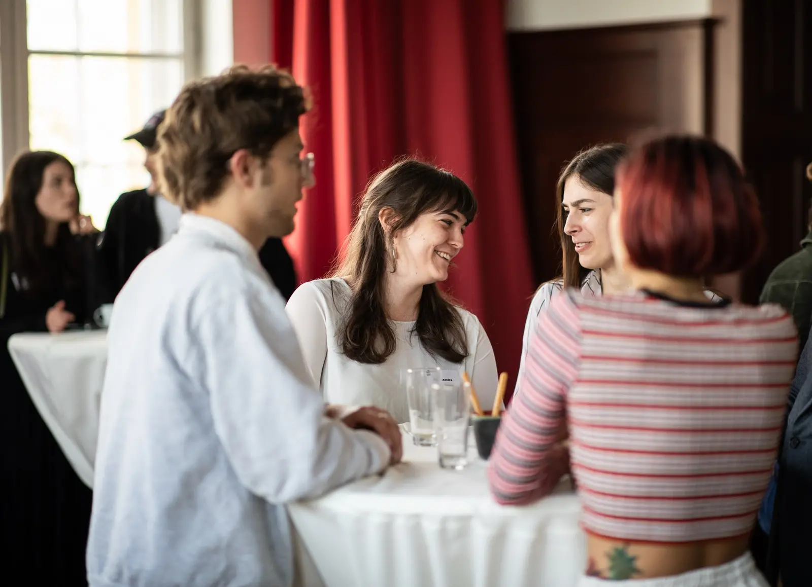 Deutschlandstipendium Studierende stehen an einem Stehtisch und unterhalten sich