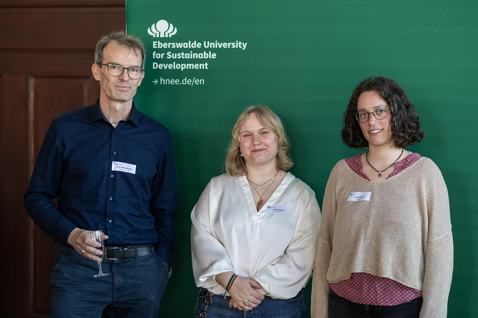 Drei Personen stehen für ein Gruppenbild zusammen