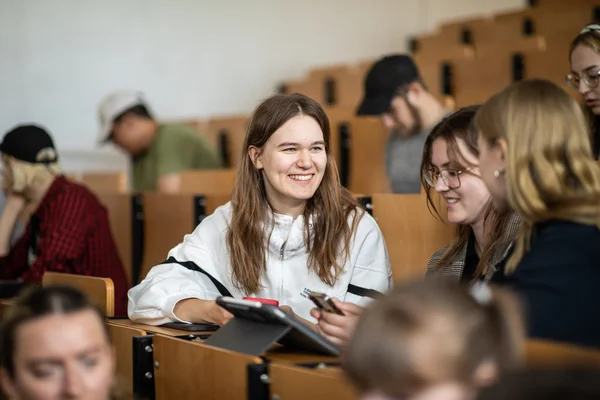 Studierende in der Vorlesung Studentinnen sitzen im Vorlesungssaal und unterhalten sich fröhlich