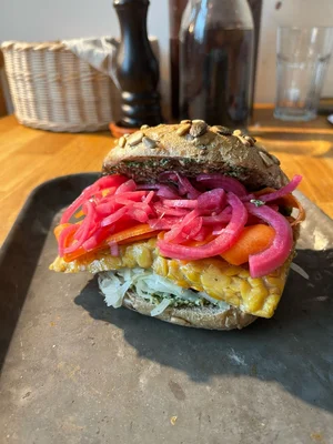 Von Studierenden für Bäcker Wiese konzipiertes Tempeh-Brötchen Im Rahmen des Moduls „Studienpartner Ökobranche“ (2. FS) entwickeltes Brötchen mit Tempeh, gepickeltem Gemüse, veganem Frischkäse und Pesto.