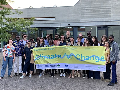 Menschen stehen rum mit nem Banner