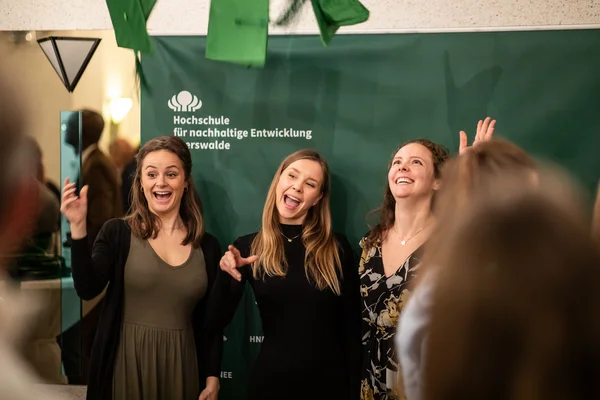 Abschlussfeier 2024 Drei Absolvent*innen schmeißen ihren Graduation-Hut in die Luft.
