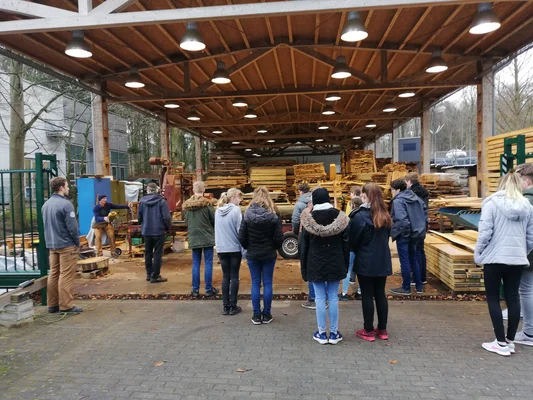 Future Day eine Gruppe Schüler*innen sieht sich eine Demonstration des Sägewerks an.