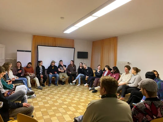 Menschen sitzen im Kreis
