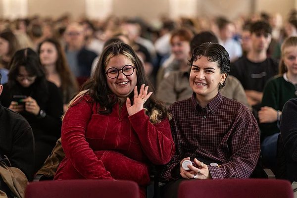 Zwei Personen sitzen im Publikum der Immatrikulationsfeier.