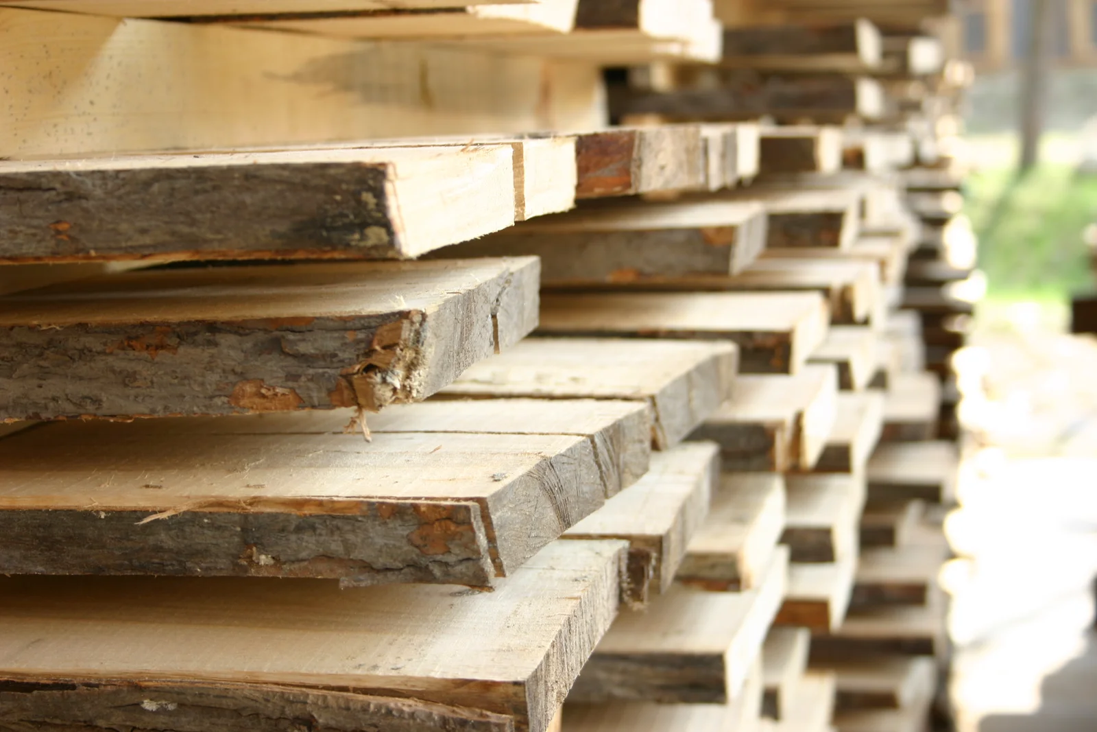 Stack of sawn timber Gezeigt wird ein Stapel gesägter Bretter aus Buchenholz mit Rinde.