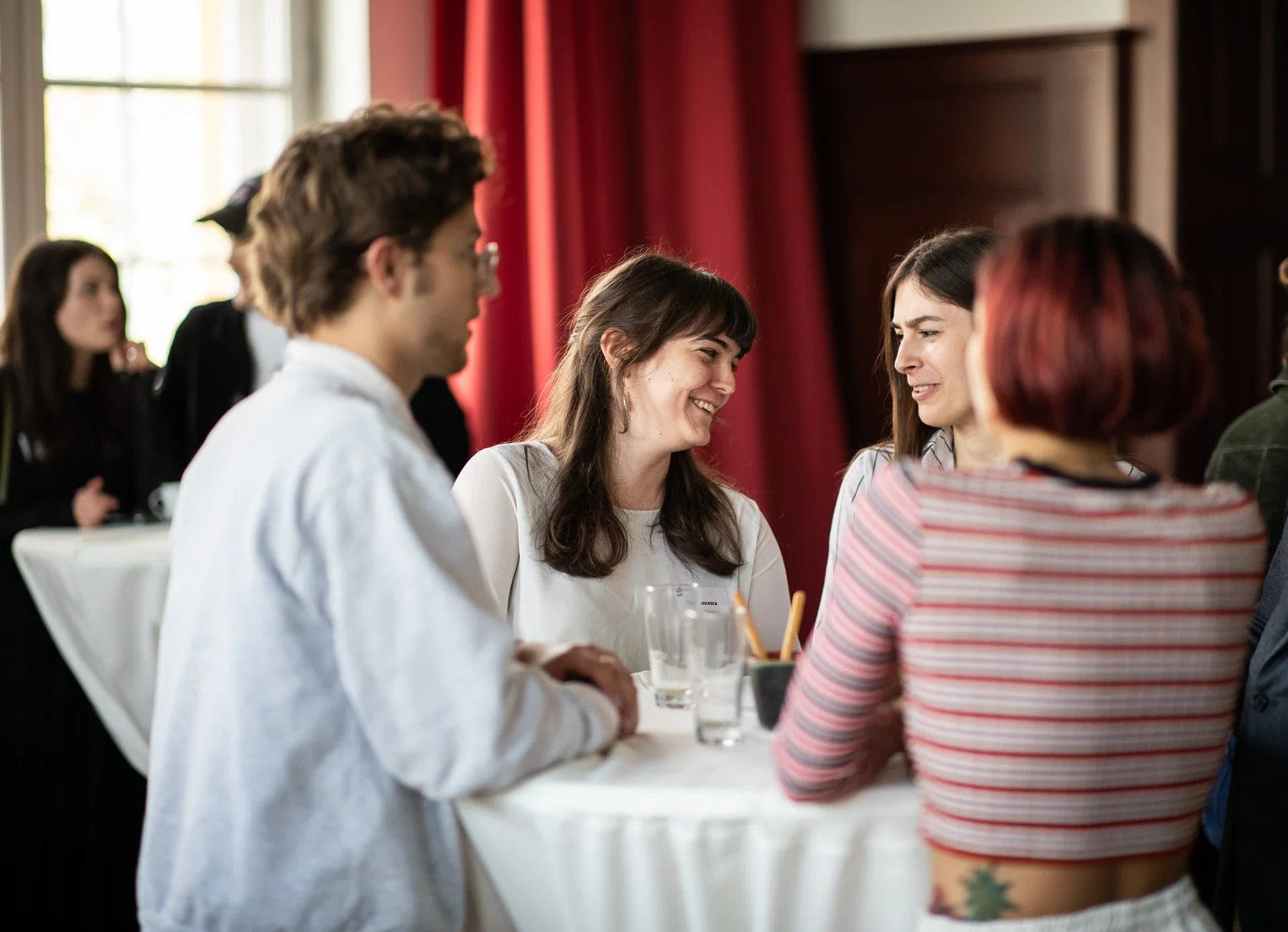 Deutschlandstipendium Studierende stehen an einem Stehtisch und unterhalten sich