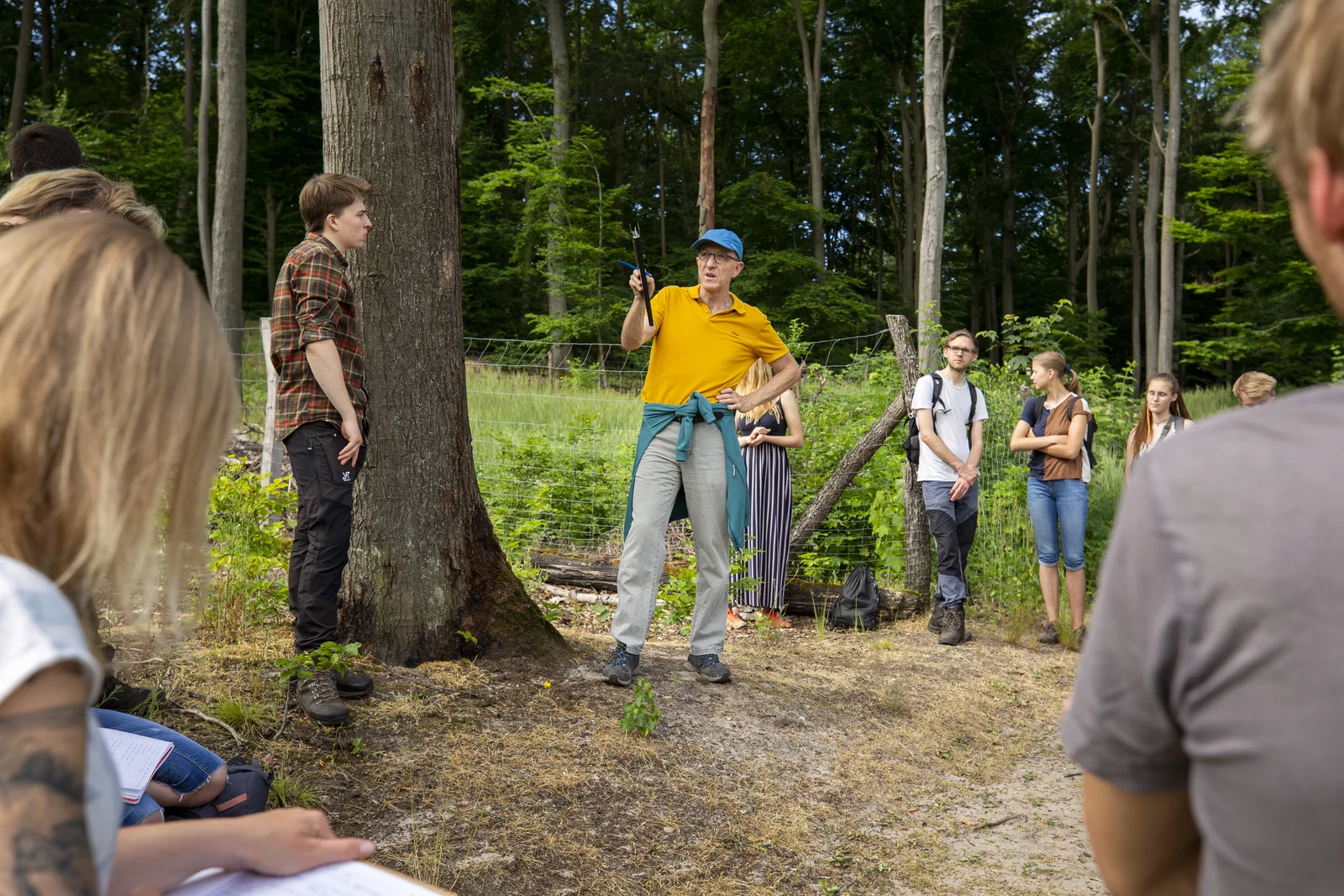 Vorlesung auf Windwurffläche mit Prof. Dr. Peter Spathelf Ein Professor erklärt im Wald und Studiere hören und zu und schreiben mit.