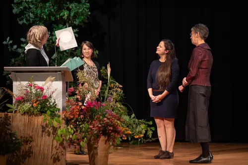 Two laudators, the award winner and the Vice President are on stage.