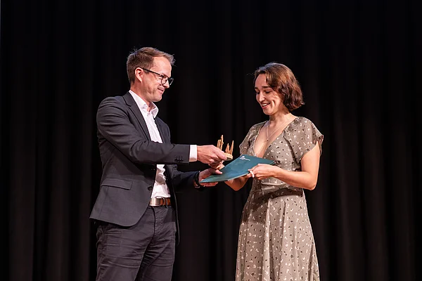Ein Vertreter der Stadt Eberswalde übergibt den Nachhaltigkeitspreis an eine Studentin.