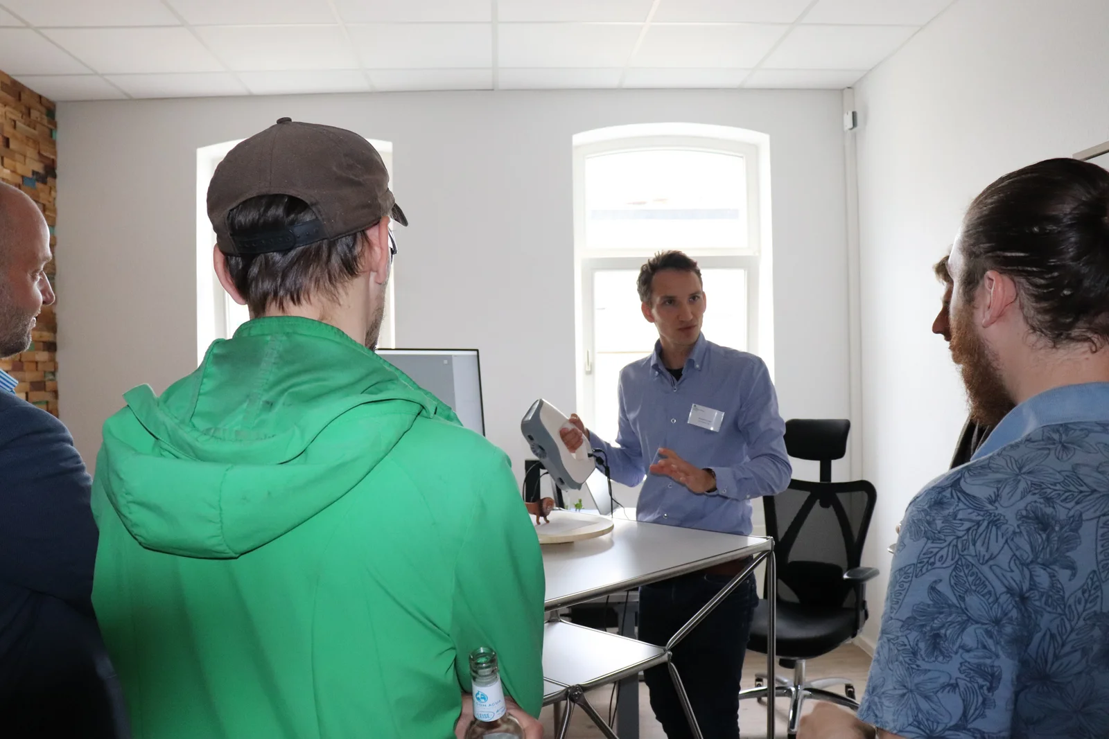 StartupLab In einem Seminarraum des StartupLab zeigt ein Mitarbeiter Interessierten den 3D Handscanner. Dieser sieht einem Tischstaubsauger recht ähnlich.
