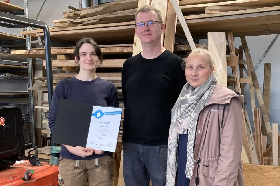 Auszubildende Tischlerin Emely Jusko – Lehrling des Monats Auszubildende Tischlerin Emely Jusko (links) zeigte beeindruckende Leistungen und Engagement in ihrer Ausbildung als Tischlerin an der HNEE und erhielt 2023 die Auszeichnung „Lehrling des Monats“. Neben ihr zu sehen: Mitarbeiter der HNEE Michael Günther und Ausbildungsverantwortliche der Hochschule Stephanie Sperfeldt
