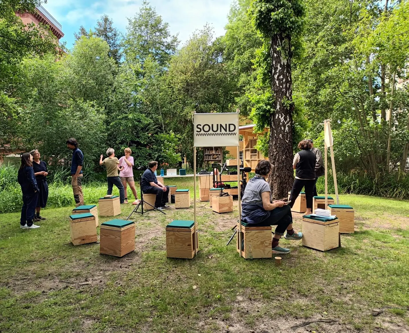 open academy SOUND Draußen auf dem Stadtcampus der HNEE sitzen die Teilnehmenden der open academy unter Bäumen