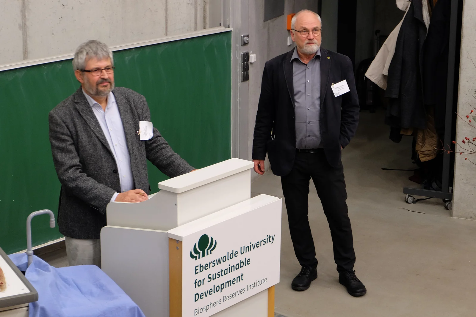  Two men are standing on a podium. 
