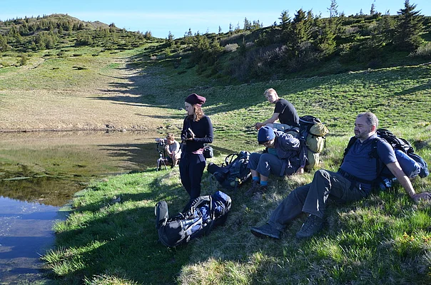 Small hiking group at alpine lake